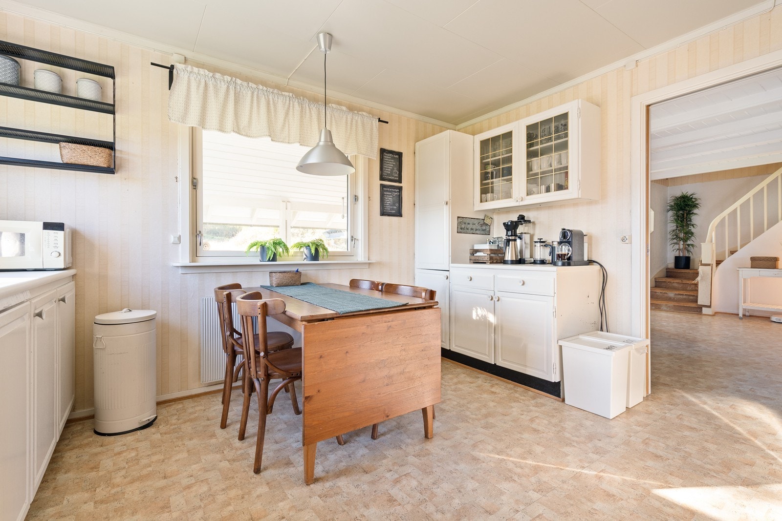 Romslig kjøkken med malte speilfronter, laminat benkeplate, stål oppvaskkum, mekanisk ventilator og frittstående hvitevarer. Galleribilde