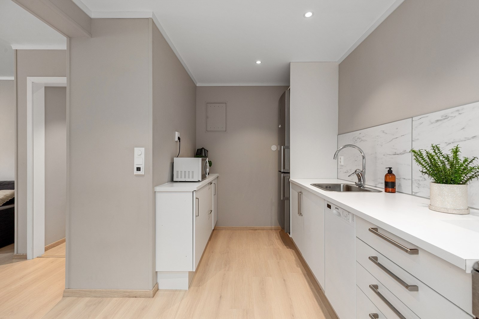 Kjøkkenet har glatte kvite frontar og laminat benkeplate. Galleribilde