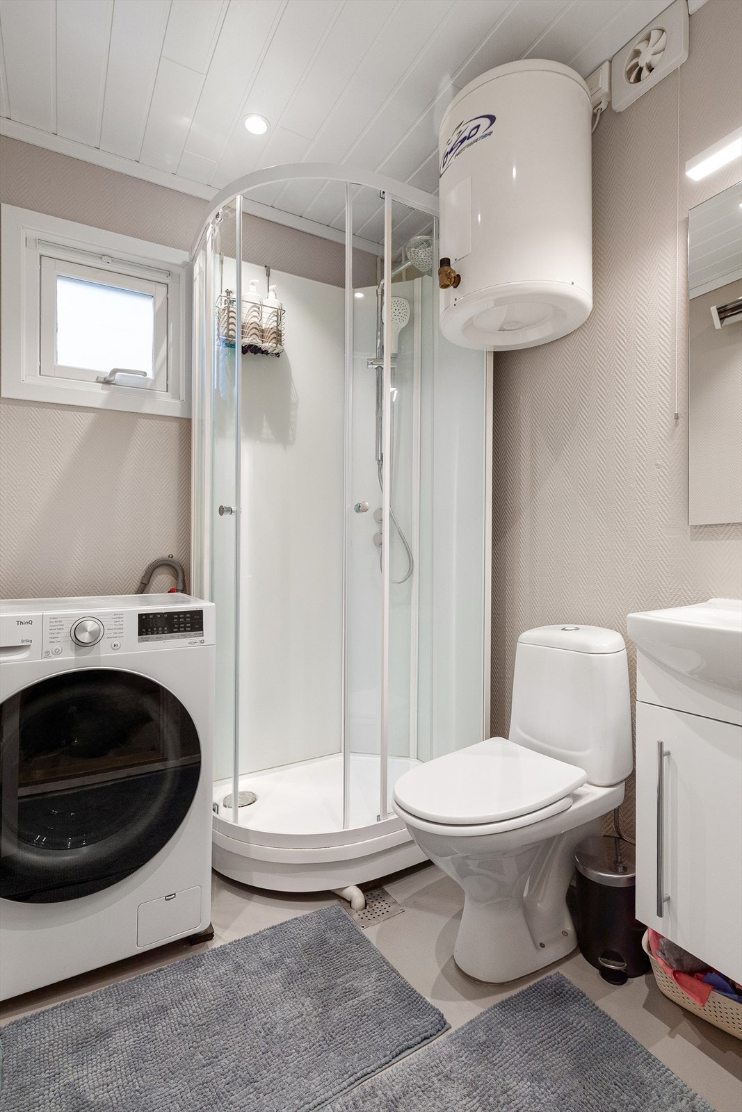 Badet har strielagte veggar og belegg på golv. Badet er utstyrt med wc, baderomsinnredning med heildekkande servant, opplegg for vaskemaskin, dusjkabinett frå viking bad og varmtvannstank. Galleribilde