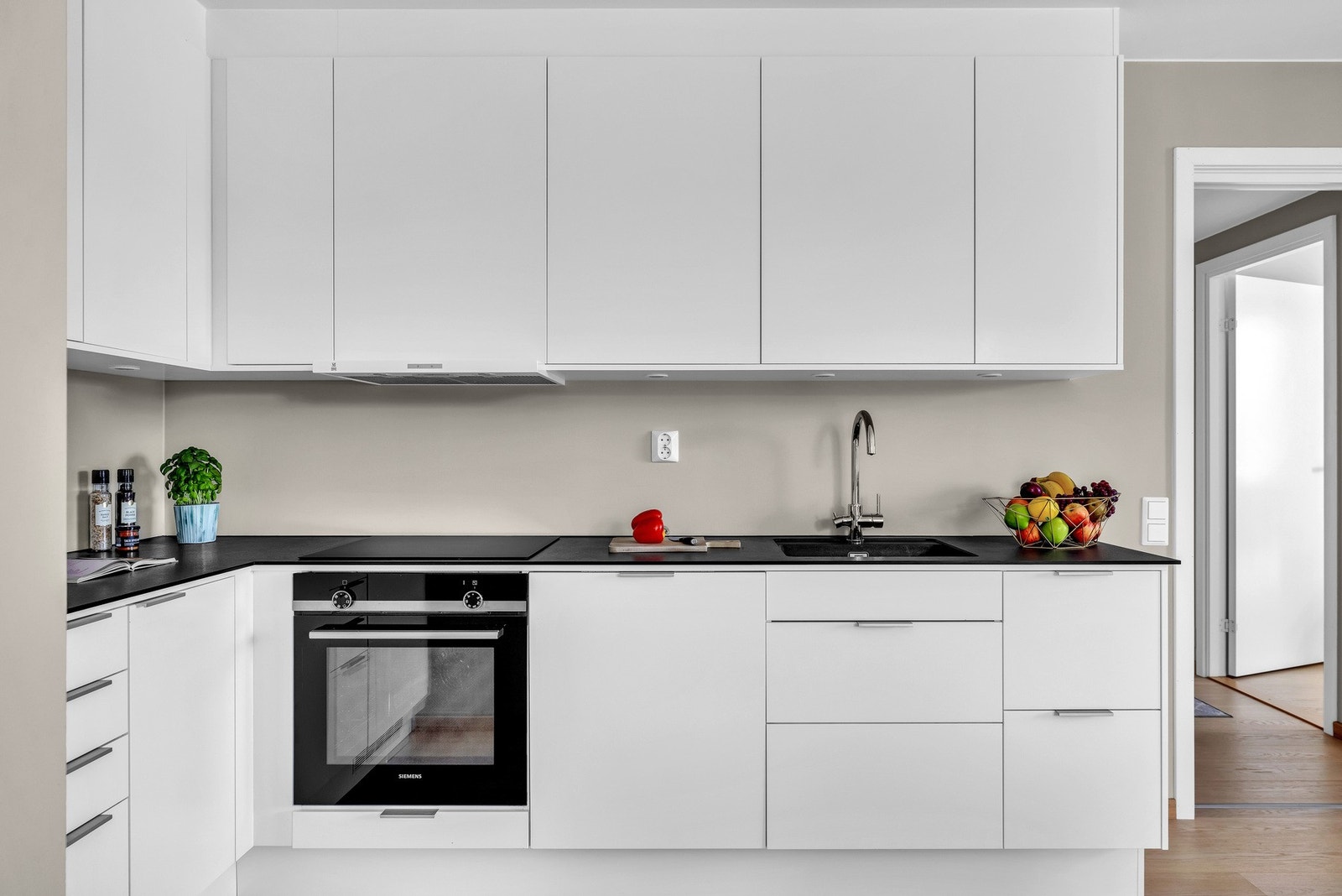 Kjøkkenet ligger i en hendig L-form med downlights fra overskapene og stikkontakter. Galleribilde