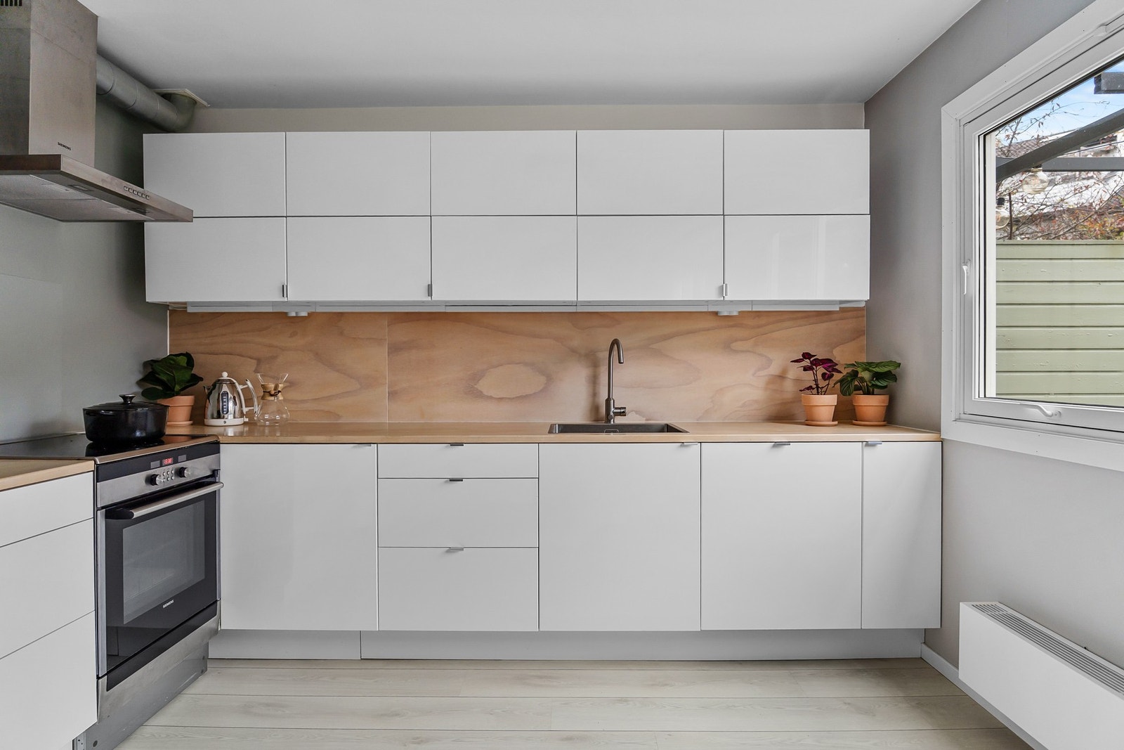 Kjøkkenet har laminatgulv, malte vegger og malt himling som gir et rent og harmonisk uttrykk. Det er ventilatorhette med avtrekk ført opp til takhette Galleribilde