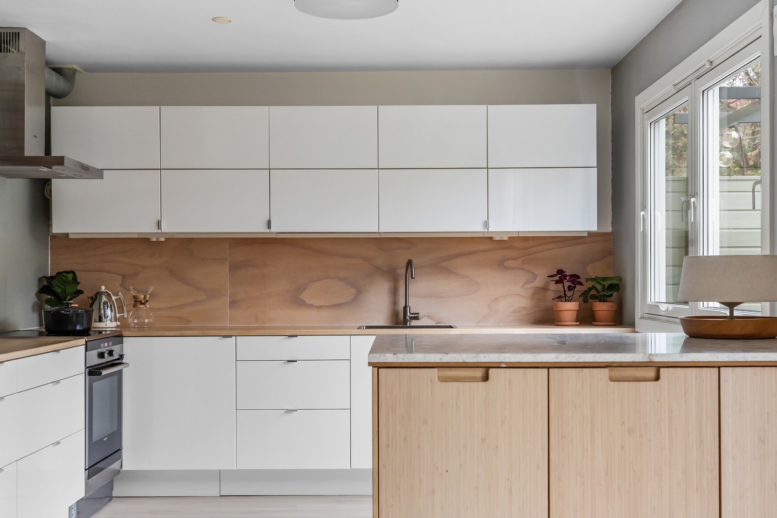 Boligen har et lyst og moderne kjøkken med glatte, hvite fronter og benkeplate i heltre bjørk - et vakkert og varmt naturmateriale som gir en lun atmosfære. Benkeplaten har nedfelt stålkum og ettgreps kjøkkenkran Galleribilde