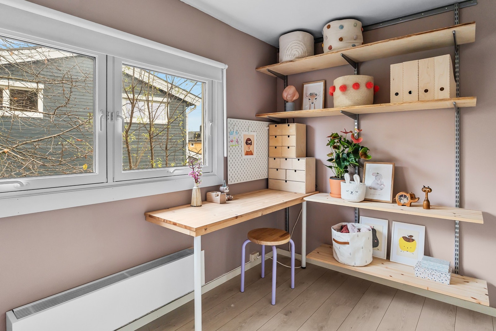 Veggmonterte hyller og skrivebord gir gode oppbevaringsmuligheter Galleribilde