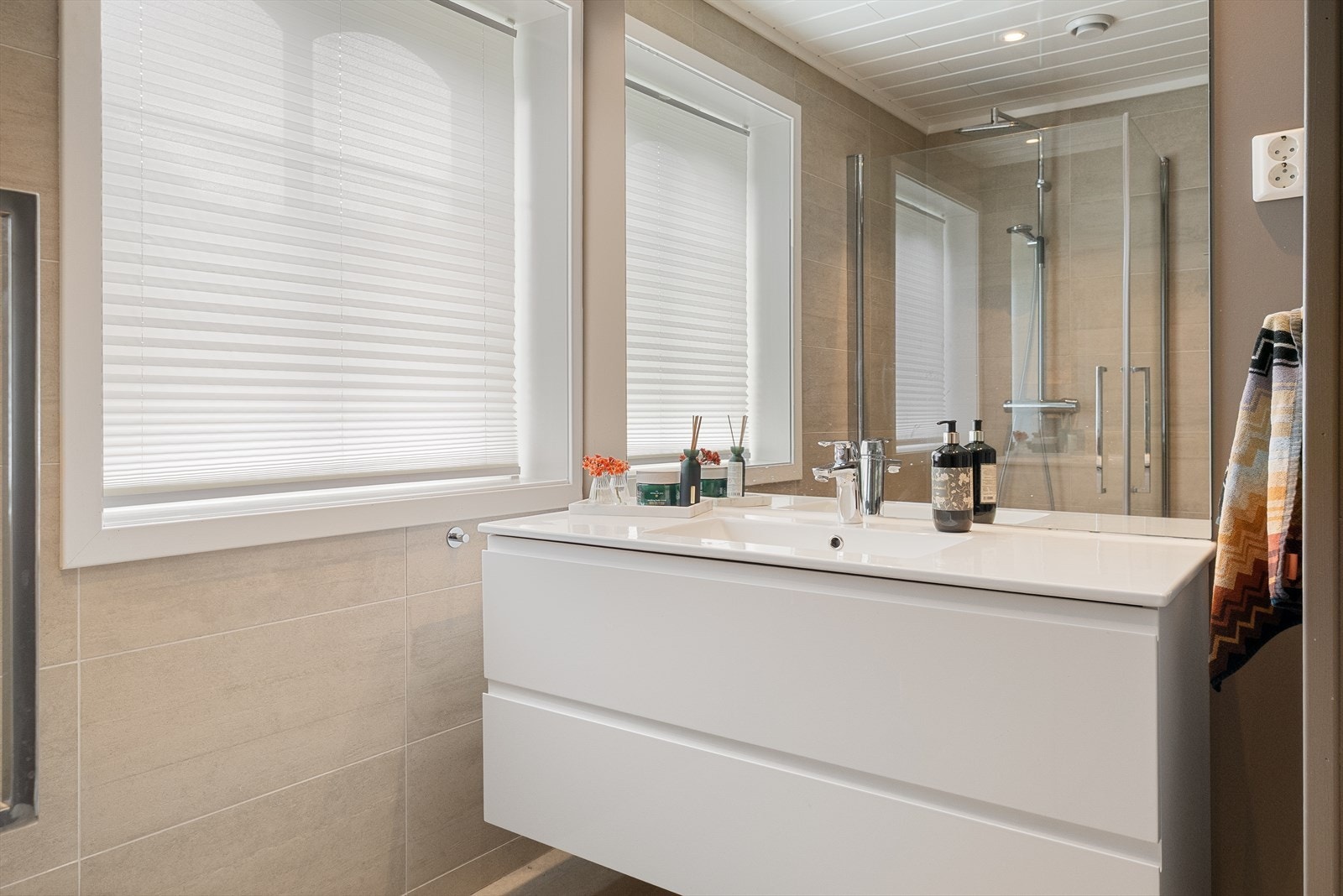 Bad i hovedetasje - innredet med servantskap med servant, vegghengt dusj med skjermdører i herdet glass. Galleribilde