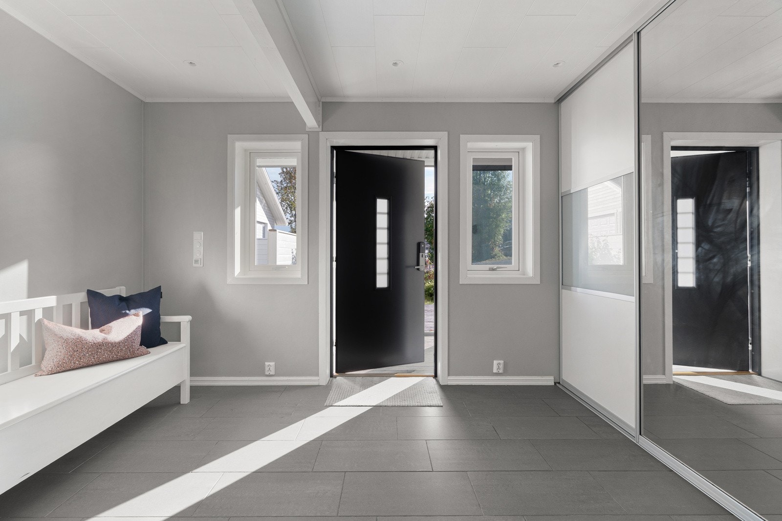 Romslig entré med stor skyvedørsgarderobe med gode lagringsmuligheter for yttertøy og sko