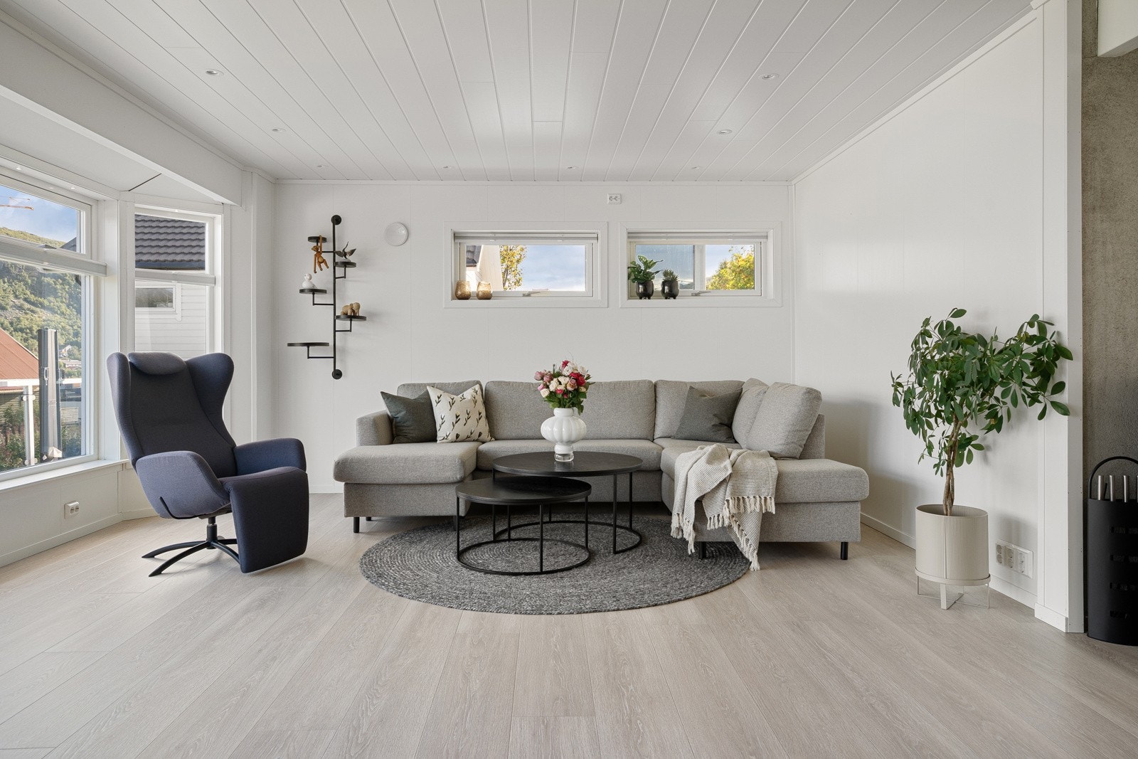 Stuen har vegger malt i lyse farger, laminatgulv og innfelte downlights i himling.