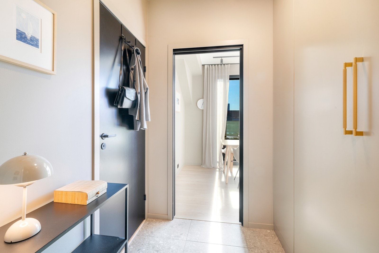 Fra felles trappeoppgang eller med heisadkomst kommer man inn i leilighetens gang med plassbygd garderobe fra Grindberg. Her er det 60/60 fliser og vannbåren gulvvarme. Galleribilde