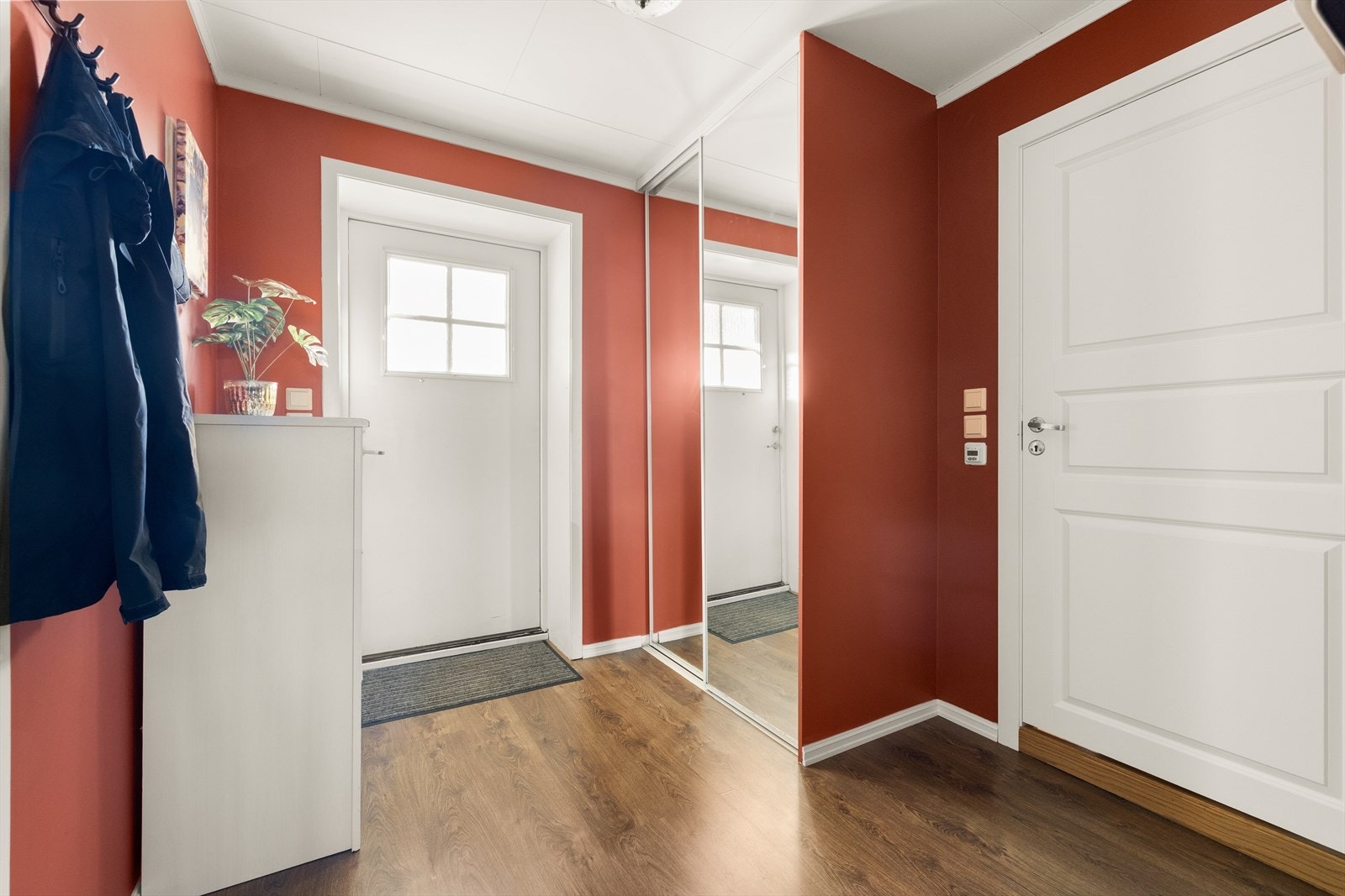 Gangen har en praktisk oppbevaringsløsning med skyvedørsgarderobe med speil. Galleribilde