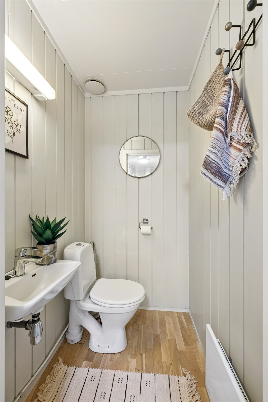 Separat toalettrom med parkett på gulv, panel på vegg og himlingsplater i taket. Rommet er innredet med vask og gulvmontert toalett, naturlig avtrekk. Galleribilde