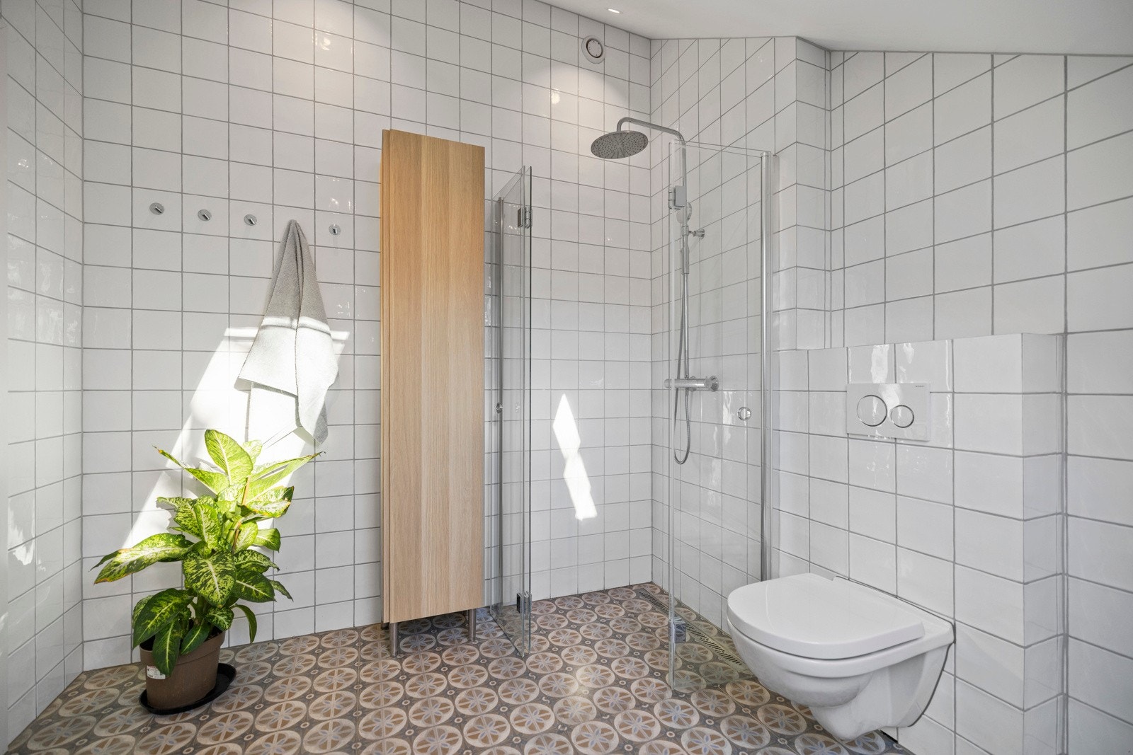 Her finner du en veggmontert WC, servant med innredning, badekar, dusjvegg og plass til vaskemaskin. Galleribilde