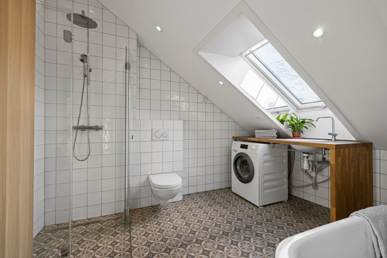 Badet på loftet ble totalrenovert i 2019 i forbindelse med innredning av loftsetasjen og har lyse fliser og elektrisk gulvvarme. Galleribilde