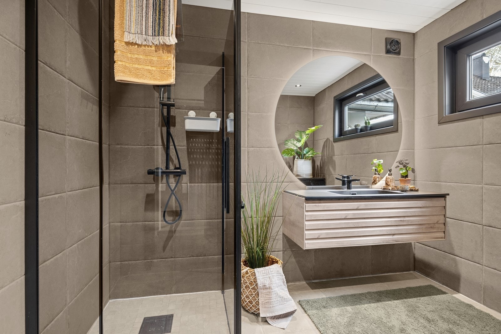 På badet er det baderomsinnredning og dusjnisje med dusjdører Galleribilde