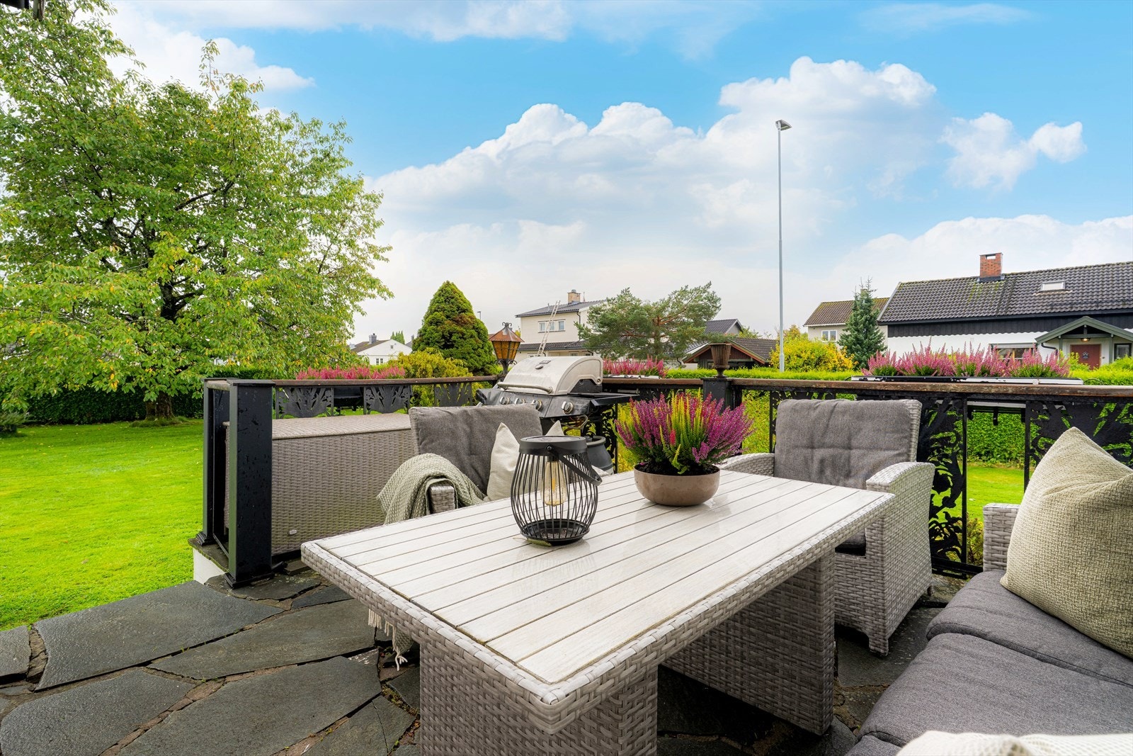 Fra spisestuen er det også utgang til en flott uteplass. Uteplassen har skiferstein og et pent, særpreget rekkverk. Det er også trapp ned til den deilige hagen. Galleribilde