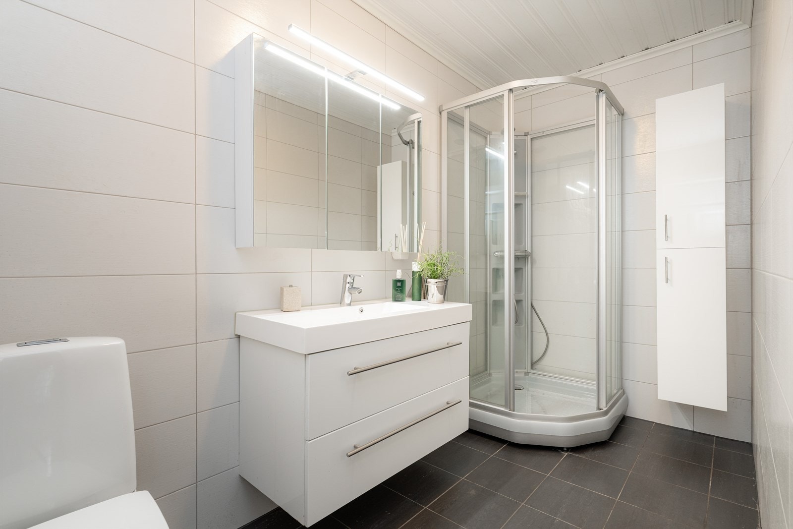 Pent bad fra 2010 med flis på gulv og vegger. Her er det toalett, dusjkabinett og innredning med heldekkende hvit vask, underskuffer med slette fronter og overskap med speildører. I tillegg høyskap med ekstra oppbevaringsplass. Varmekabler og avtrekk. Galleribilde