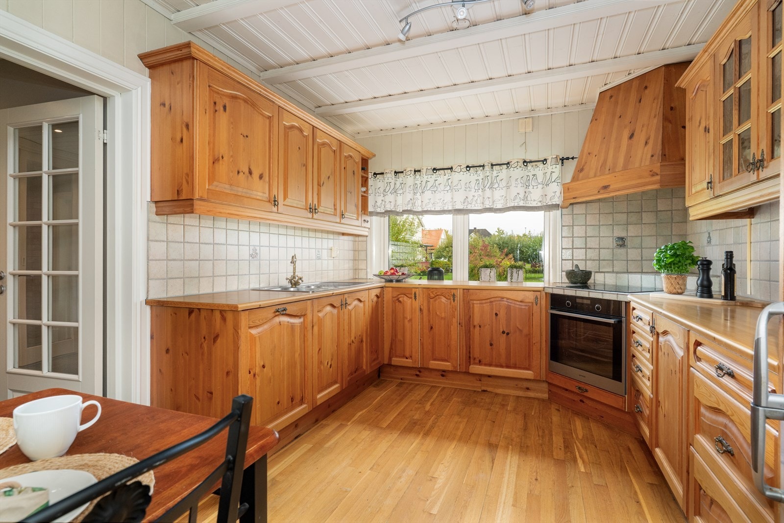 Kjøkkenet har innredning fra 1997 med profilerte fronter og noe glasskap, laminert benkeplate og flis over kjøkkenbenk. Det er ventilator med avtrekk ut og integrert oppvaskmaskin, komfyr og platetopp. Galleribilde