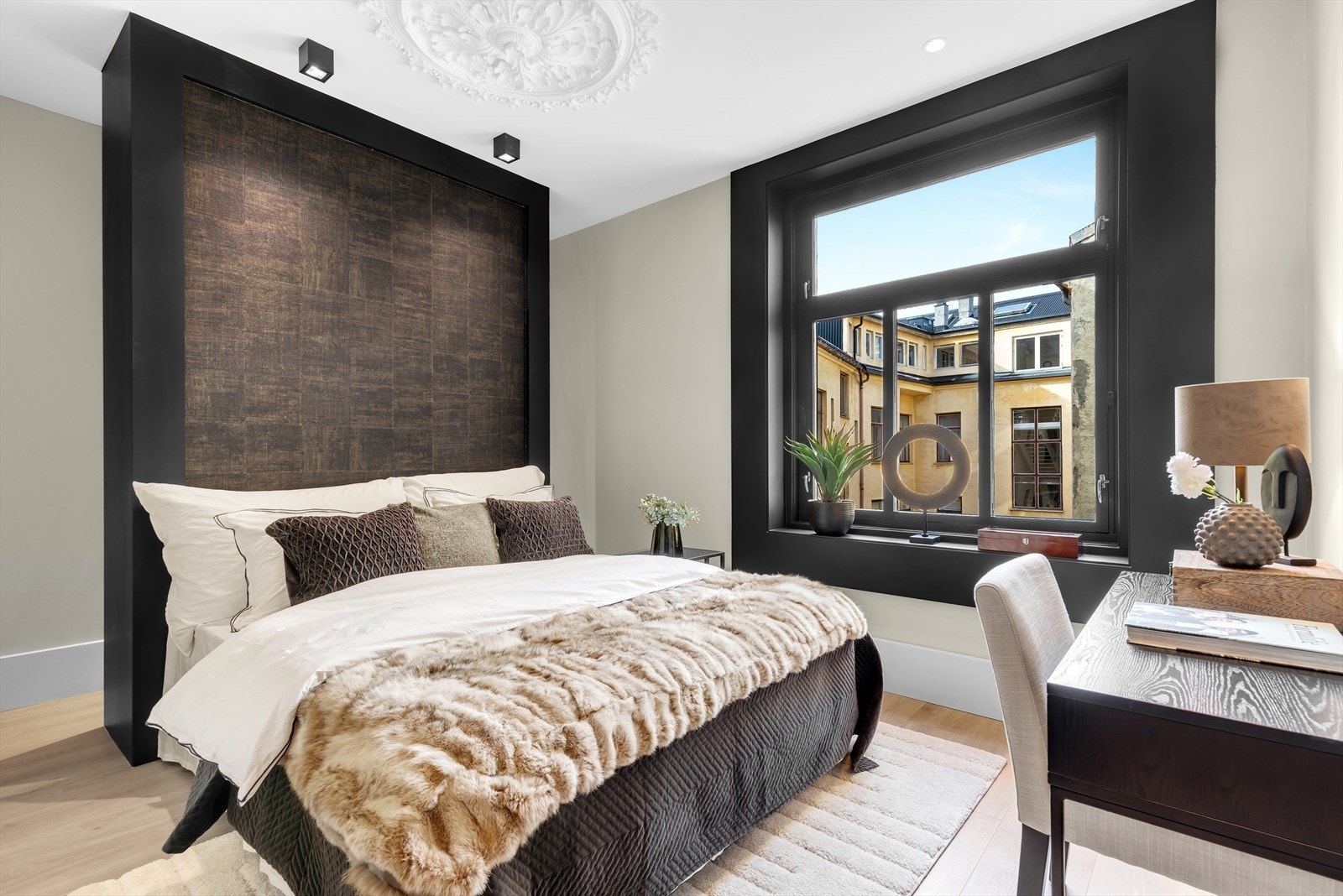 Soverom med garderobeløsning bak plassbygd sengegavl, rosett i tak og med plass til skrivepult Galleribilde