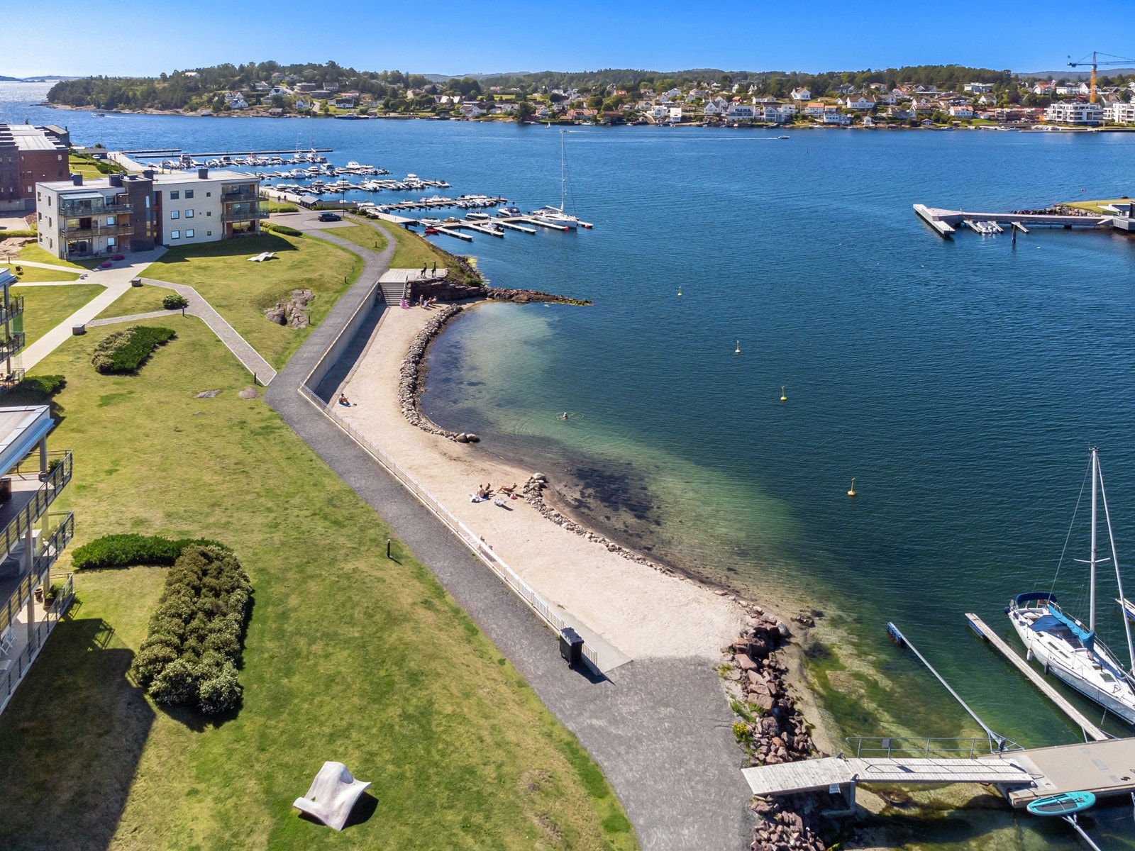 På vestsiden av øya er det en nydelig sandstrand og brygger Galleribilde