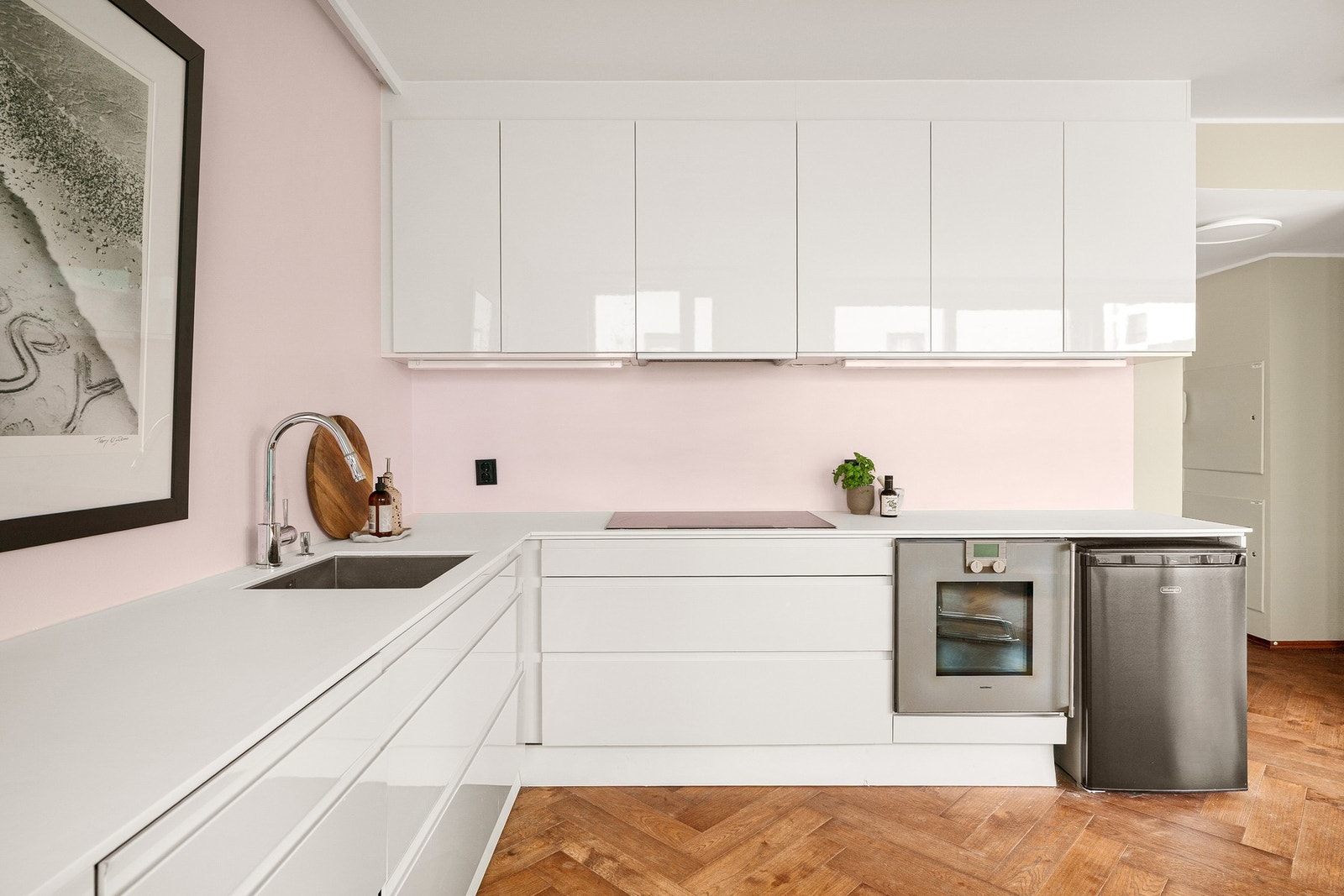 Stilren takhøy kjøkkeninnredning fra HTH med slette fronter. Corian benkeplate. Gode arbeidsflater. Galleribilde