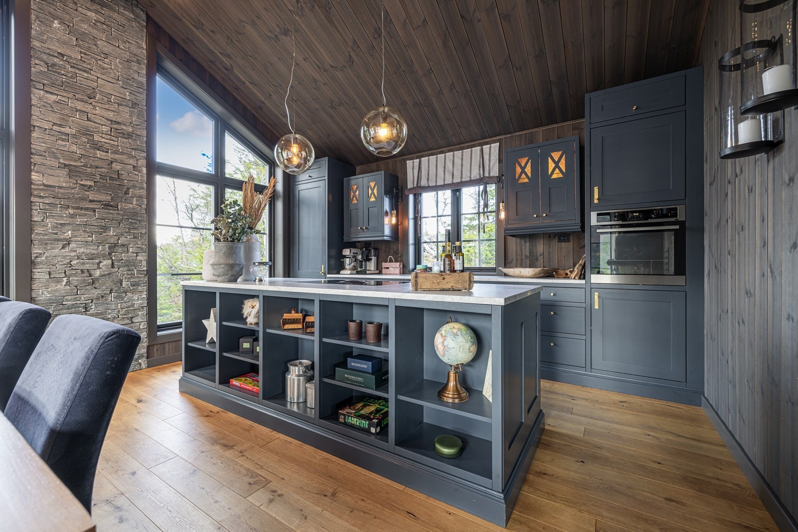 Lekkert kjøkken med profilerte fronter og kjøkkenøy, innredet med integrert kjøl/fryseskap, oppvaskmaskin og stekovn Galleribilde