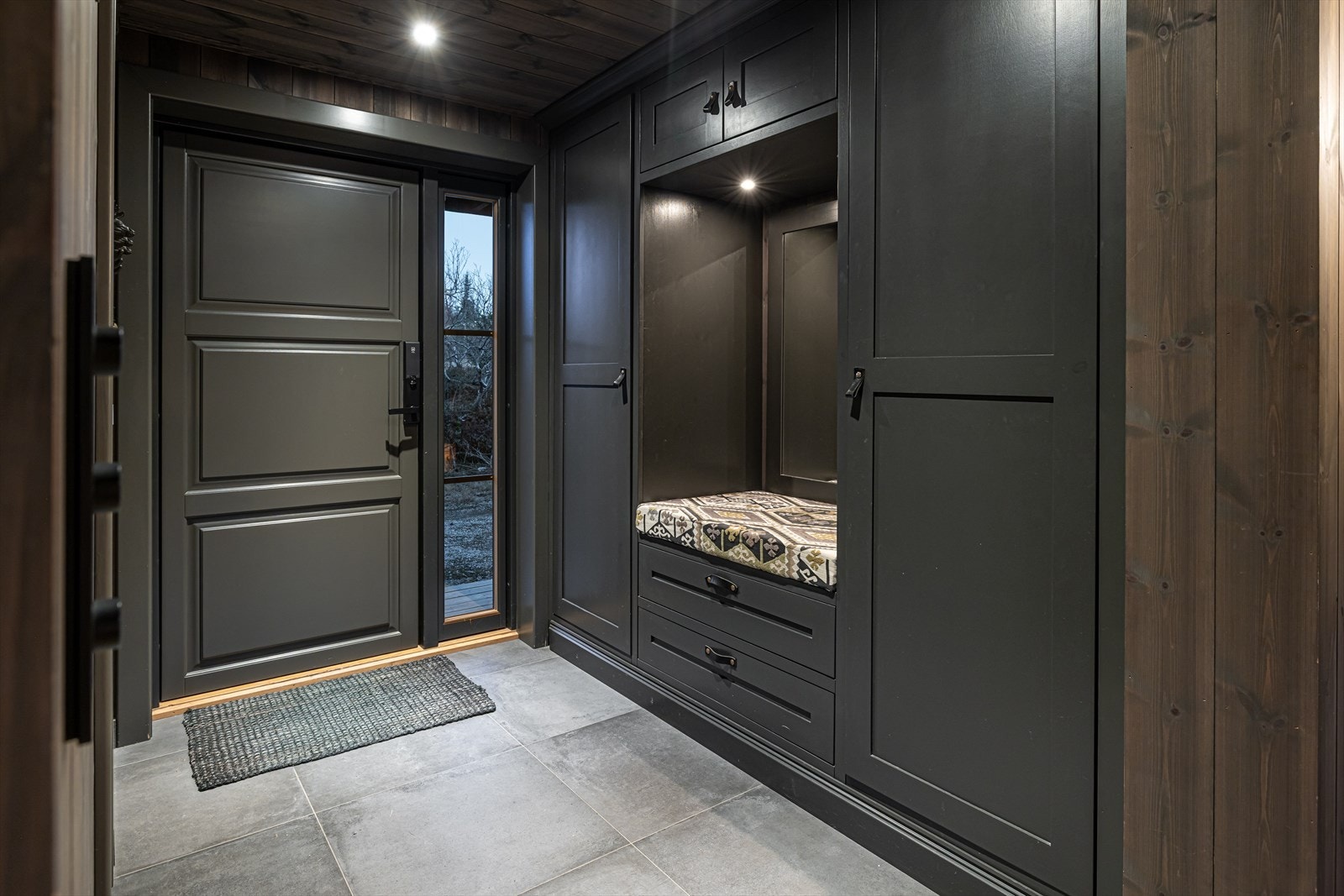 Romslig entré med plassbygde løsninger for oppbevaring og herlig gulvvarme Galleribilde