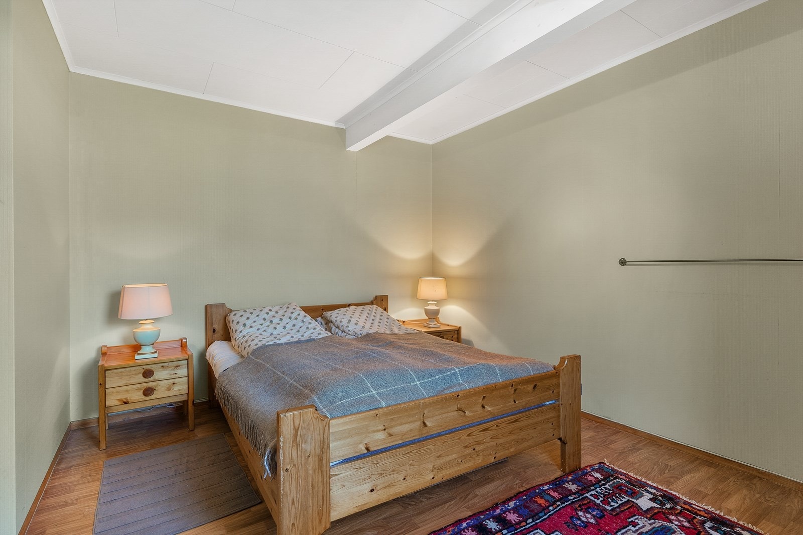 Soverom på hovedplanet med god plass for dobbeltseng og tilhørende møblement Galleribilde