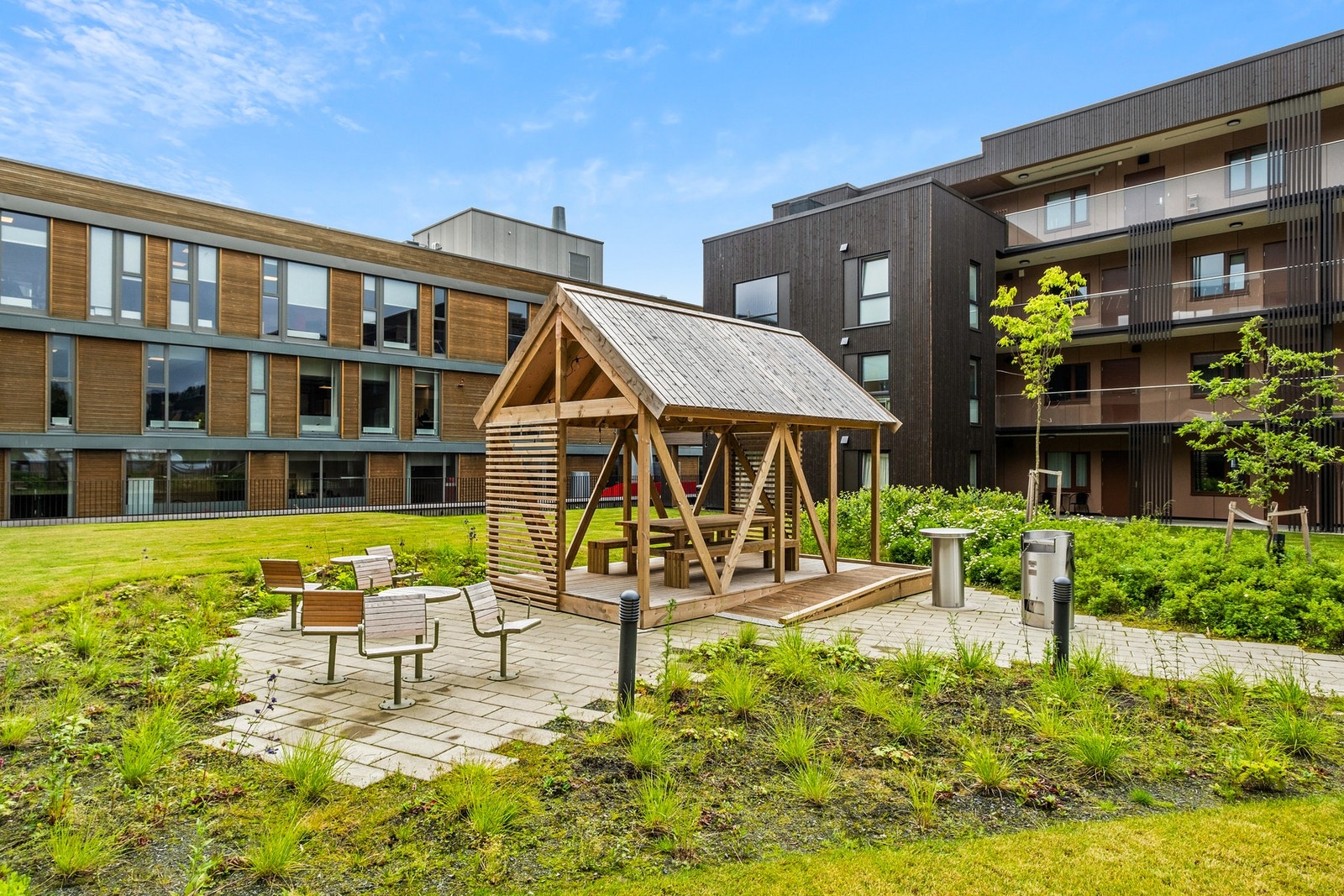 Innbydende fellesområder med beplantning og flere sitteplasser Galleribilde