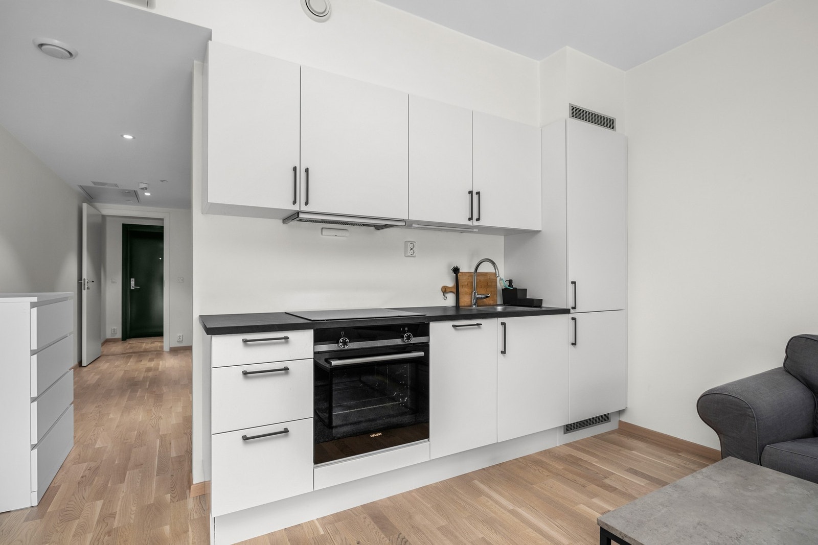 Kjøkkenet kommer med integrerte hvitevarer som kombikjøleskap, oppvaskmaskin, stekovn og platetopp Galleribilde