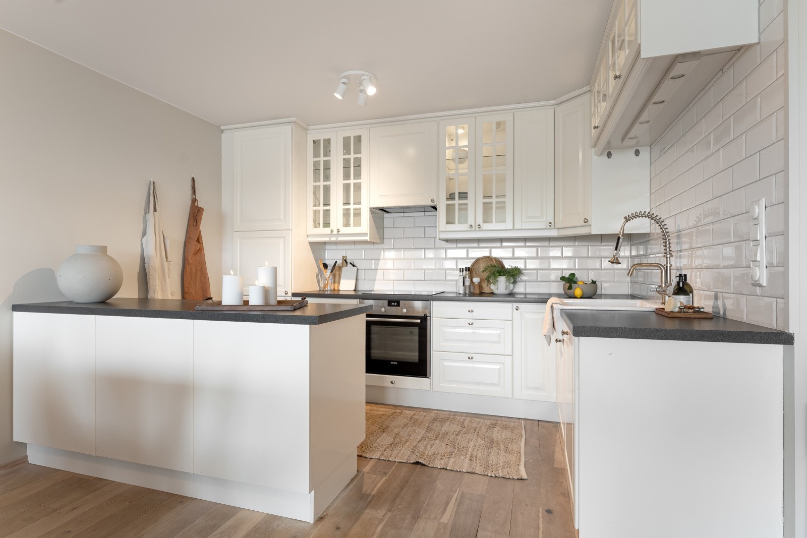 Boligens kjøkken er stilrent med profilerte fronter og laminat benkeplate. Galleribilde