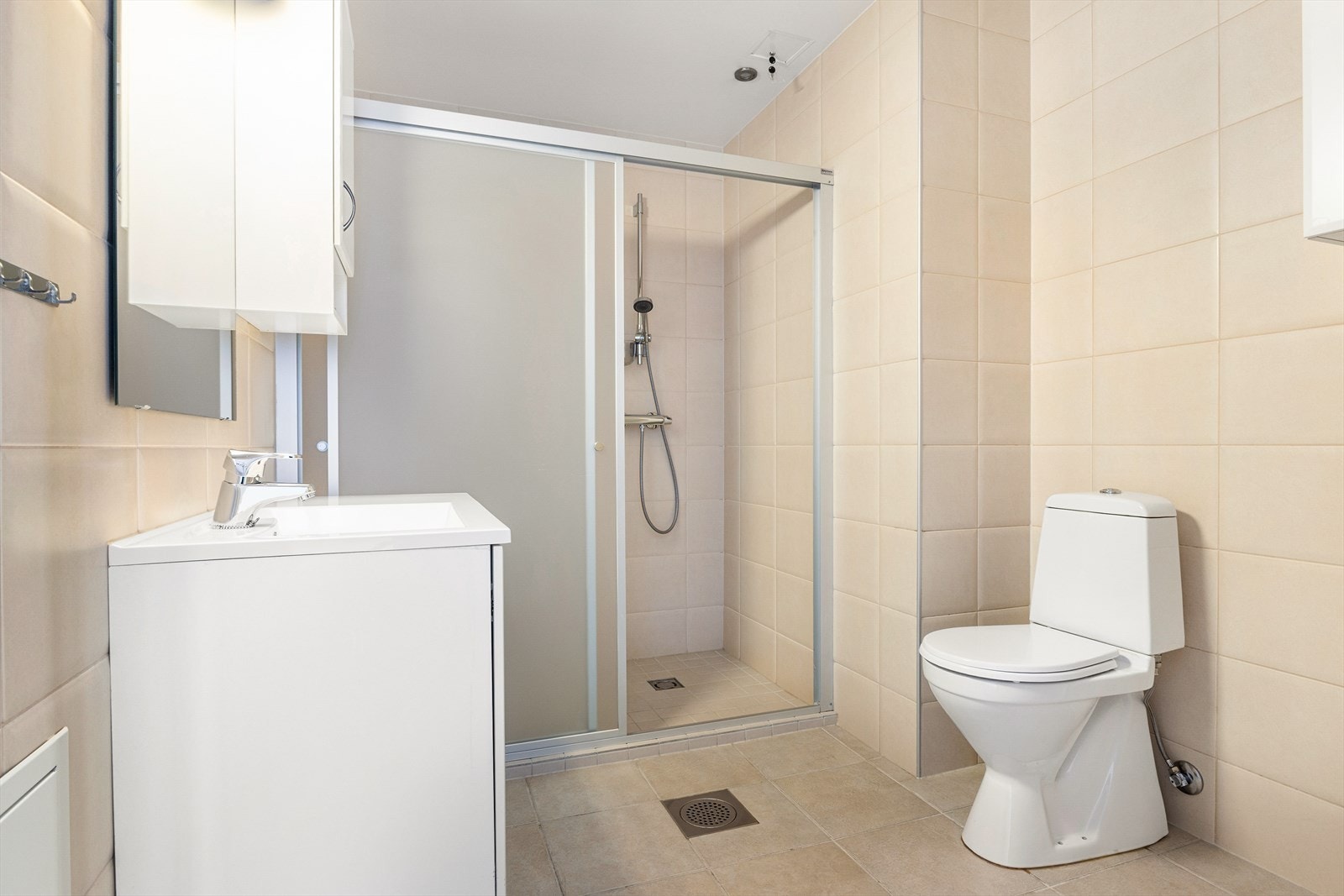 Badet er i beige flislagt utførelse. På gulvet kjenner du godt at det er elektrisk varmekabler, som sørger for en lun start på dagen. Galleribilde