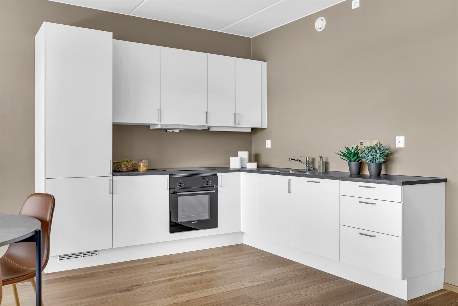 Moderne kjøkken med integrerte hvitevarer som kjøleskap/fryser, ovn, platetopp og oppvaskmaskin Galleribilde