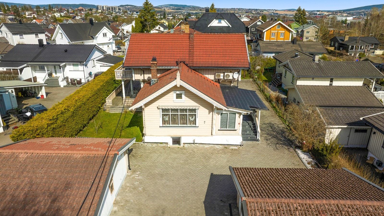 Det er gode parkeringsmuligheter. Dobbeltgarasjen til venstre tilhører boligen og elbillader er montert. Galleribilde