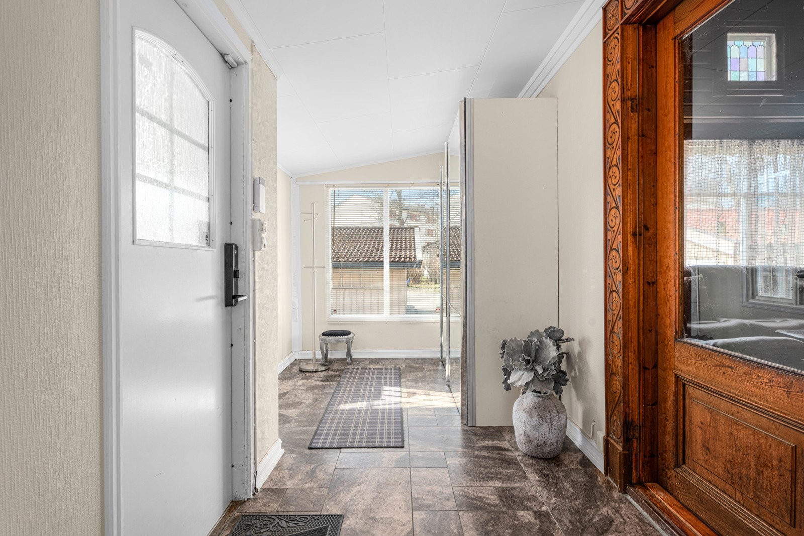 Adskilt entre med fliser og gode muligheter for oppbevaring, som gir et effektivt og ryddig inngangsparti. Galleribilde