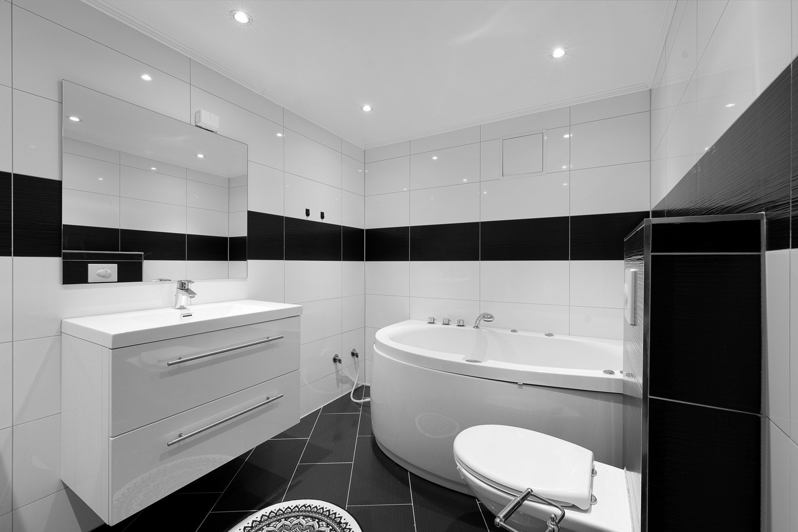 Hvitt og svart går igjen på det stilfulle badet i underetasjen. Galleribilde