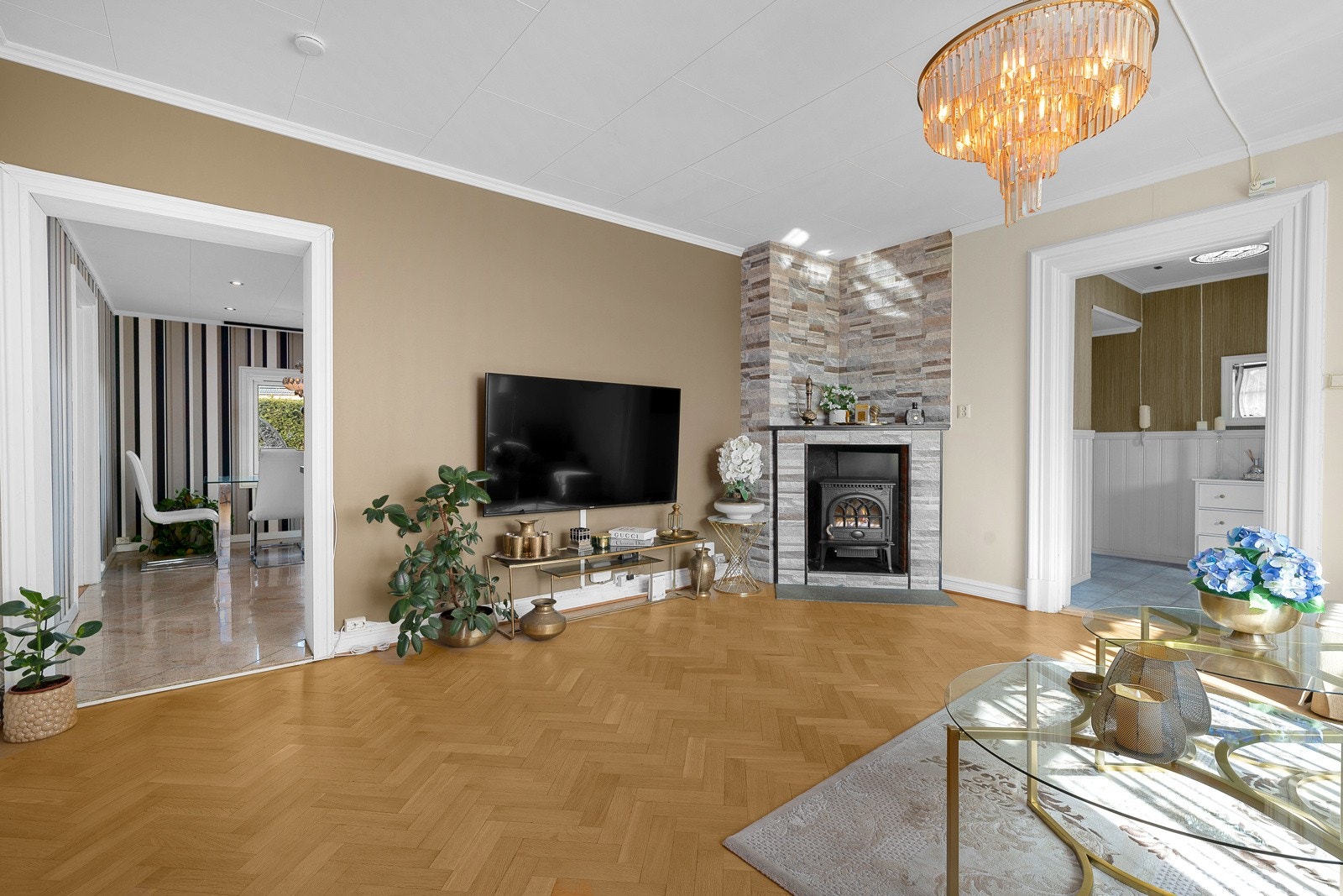 Stuen har en stor og praktfull peis plassert i hjørnet, omrammet av unike, skiferlignende fliser som gir et solid og eksklusivt preg. Galleribilde