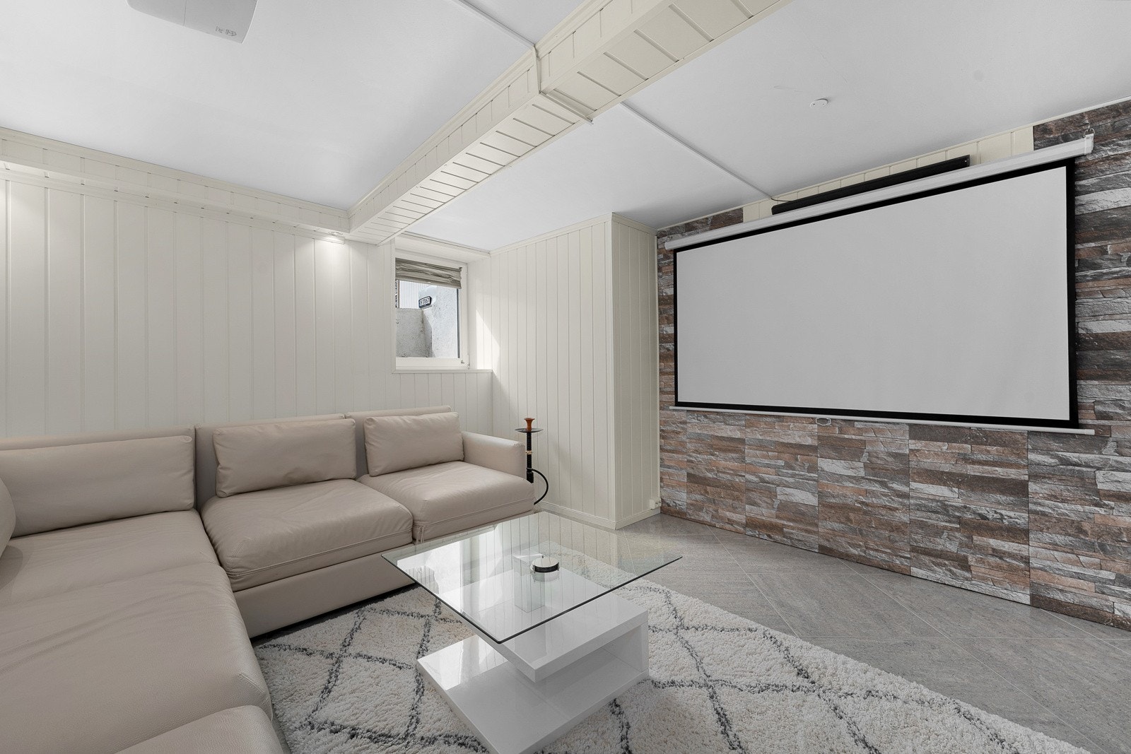 En imponerende kinostue med steinpanel, som gir et stilfullt preg, perfekt for filmkvelder og underholdning. Galleribilde