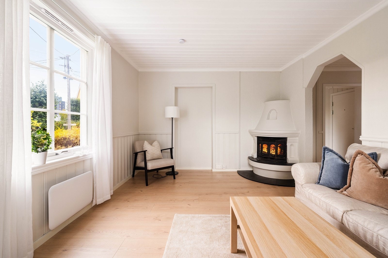 Lys og pen stue med peisovn. Galleribilde