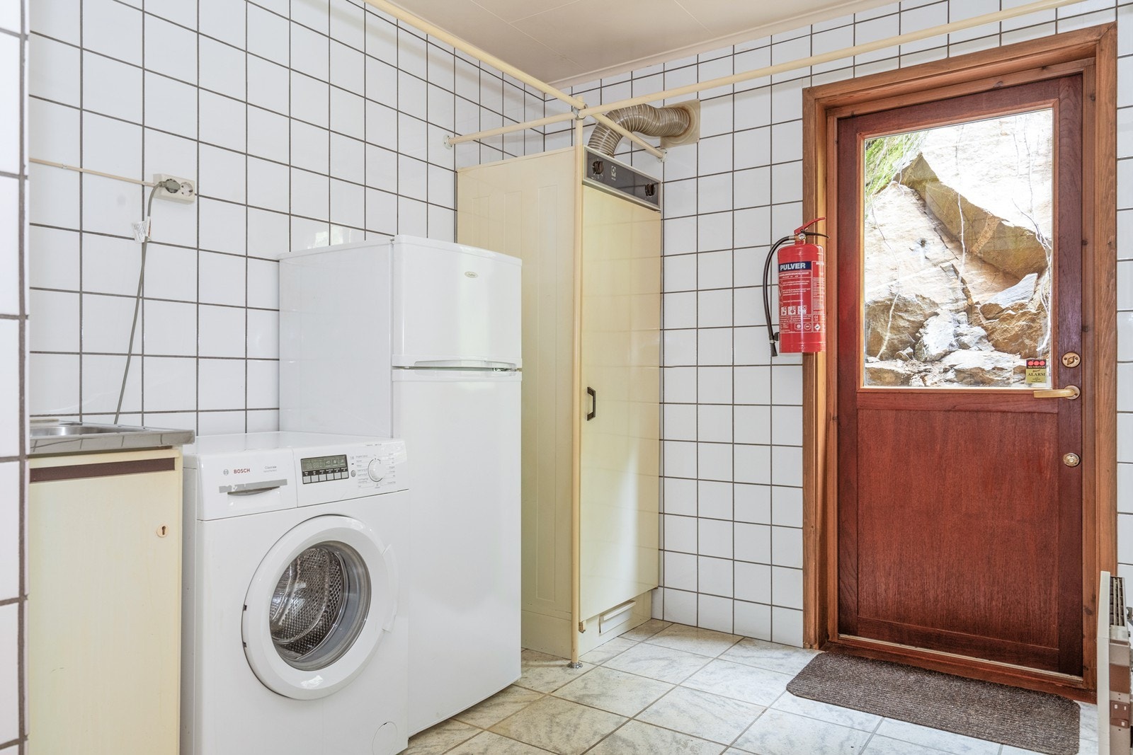 Separat vaskerom med fliser, opplegg for vaskemaskin og egen utgang gir praktisk hverdag. Galleribilde