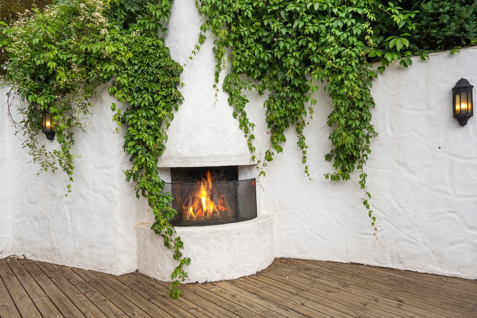 Stemningsfull utepeis omgitt av grønn beplantning gir en eksklusiv uteromsopplevelse. Galleribilde