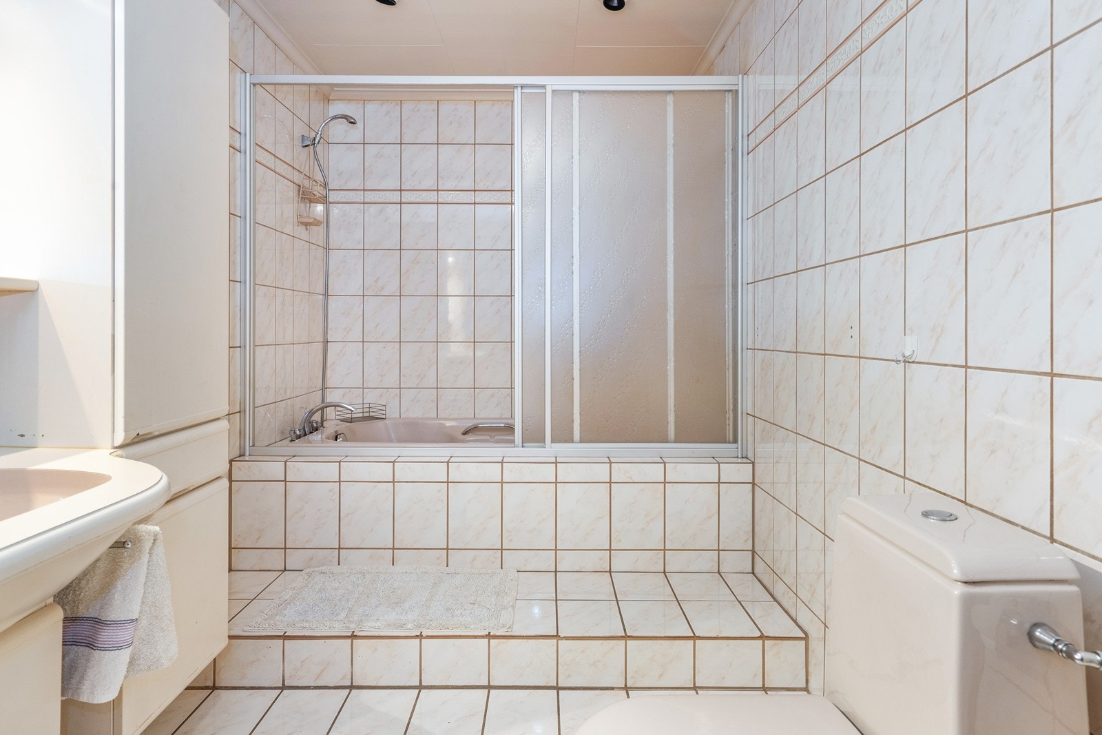 Badet i underetasjen har helflisede overflater og fleksible løsninger for hele familien. Galleribilde