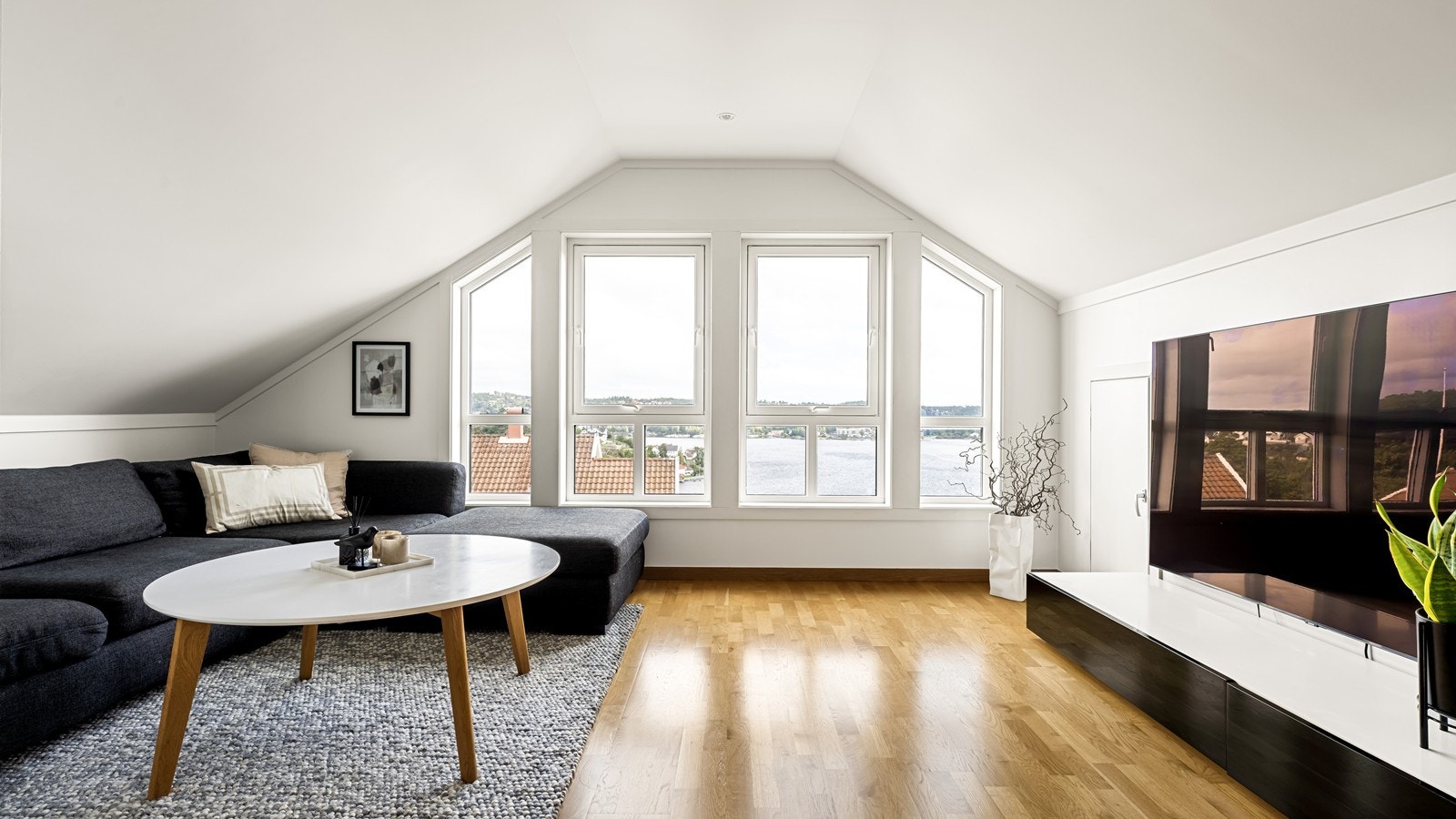 Praktisk og fin loftstue med god plass til sofa, bord og tv med tilhørende møblement Galleribilde
