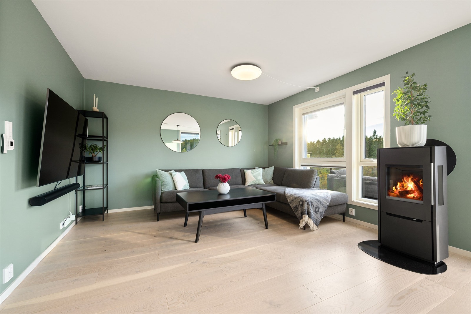 Vedovnen som står sentralt i stuen til glede for både sofakroken og spisebordet. Det er i tillegg gulvvarme i nesten hele etasjen. Galleribilde
