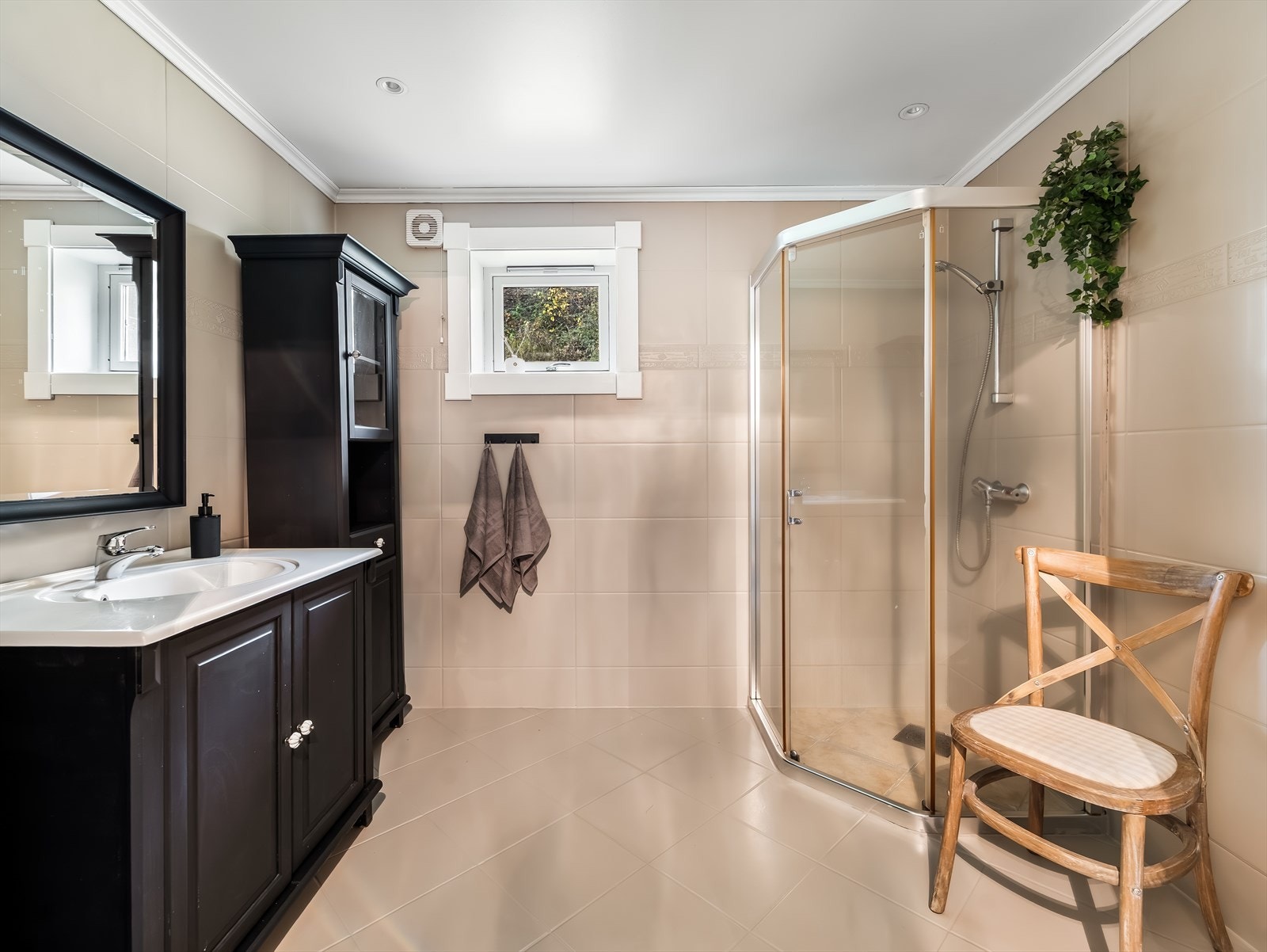 Pent bad med malte fliser. Badet er innredet med baderomsinnredning, toalett og dusjløsning. Varmekabler i gulv. Galleribilde