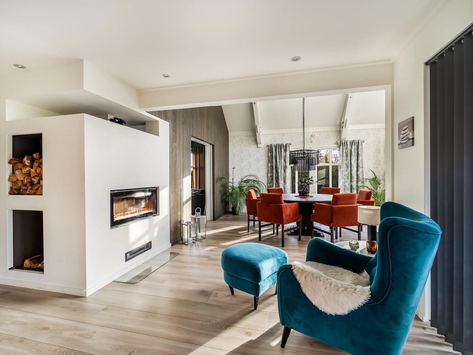 Mellom spisestue og kjøkken er det en stemningsfull peis med plass til godstol. Galleribilde