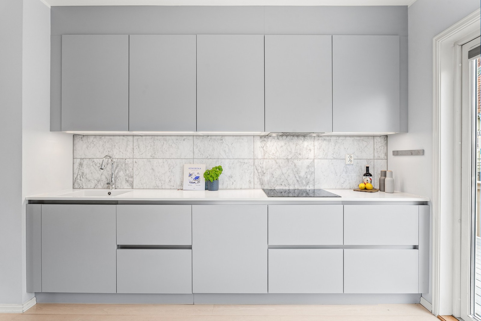 Innredningen har lyse, glatte fronter, takoppforede skap og lys laminatbenkeplate med hvit, nedfelt kum. Veggene over benken er kledd med pene fliser som står godt til resten av interiøret. Galleribilde