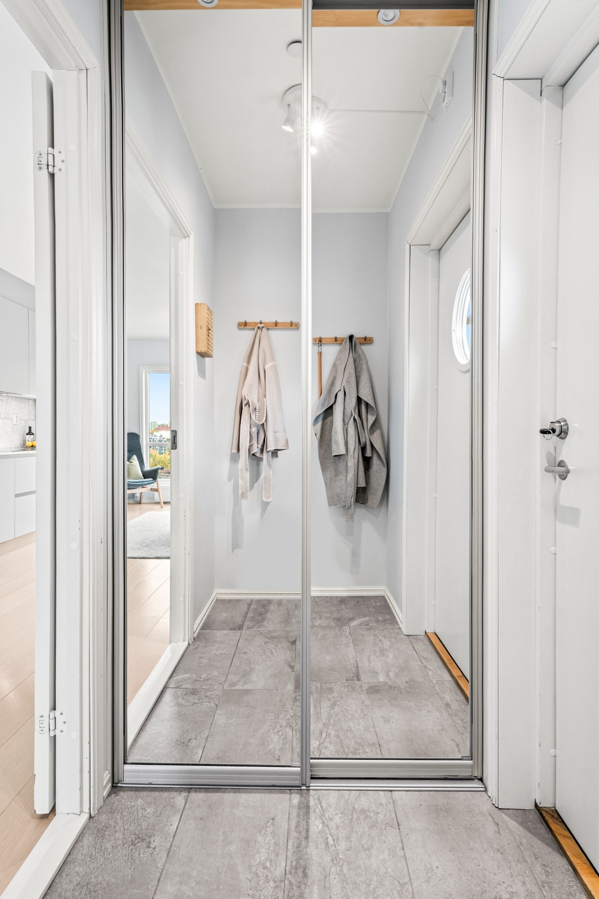 Yttertøy, sko og utstyr ryddes enkelt bort i en plassbygd skyvedørsgarderobe med speilfronter. Galleribilde