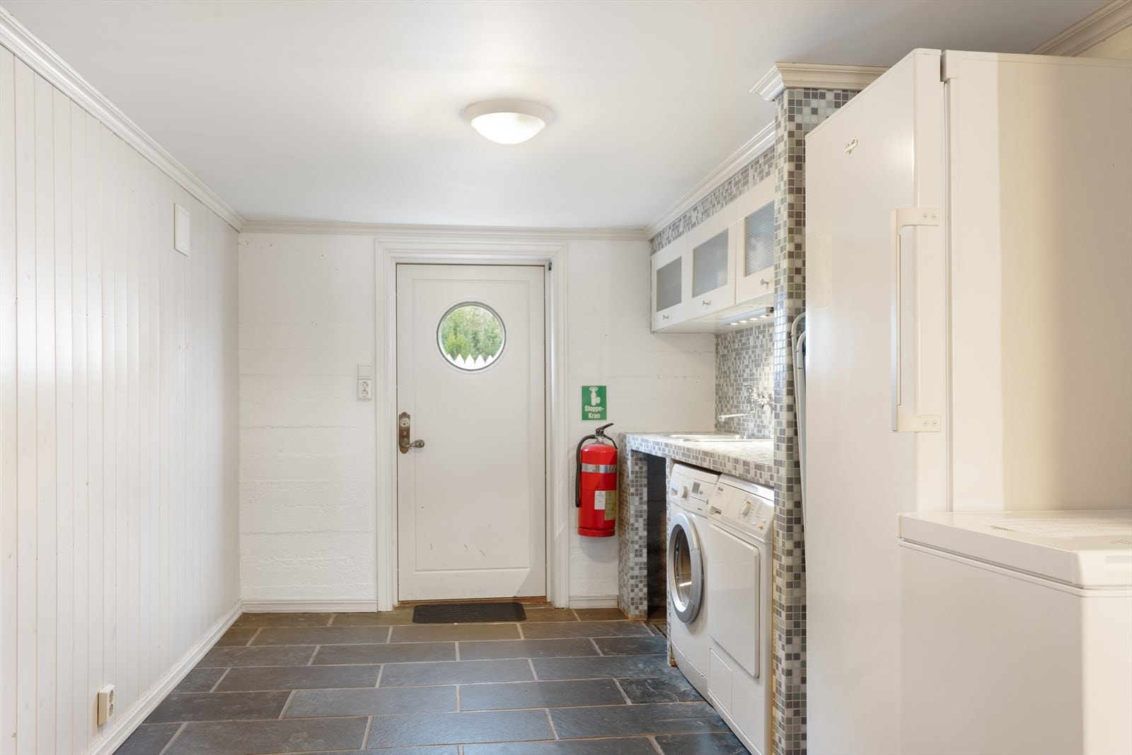 Romslig og pent vaskerom med fliser på gulv og egen inngang Galleribilde