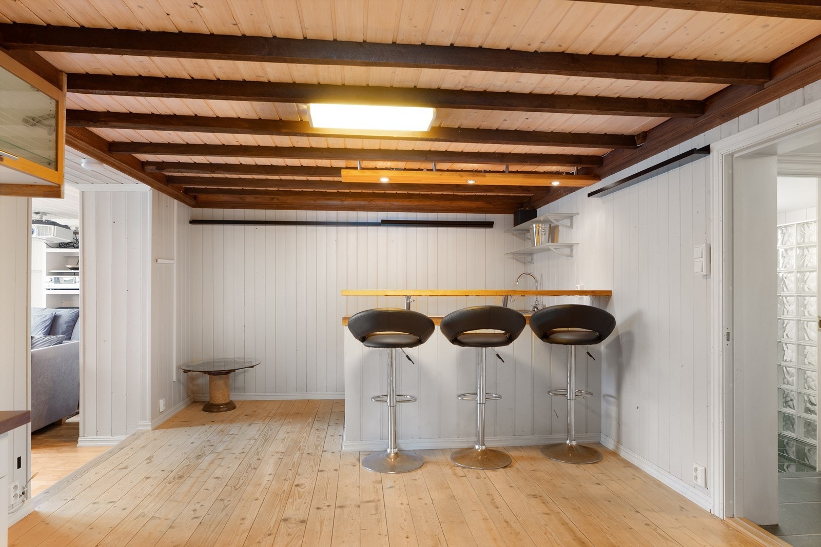 Pen todelt stue i kjelleren som har en kjekk bar-løsning i den ene delen Galleribilde