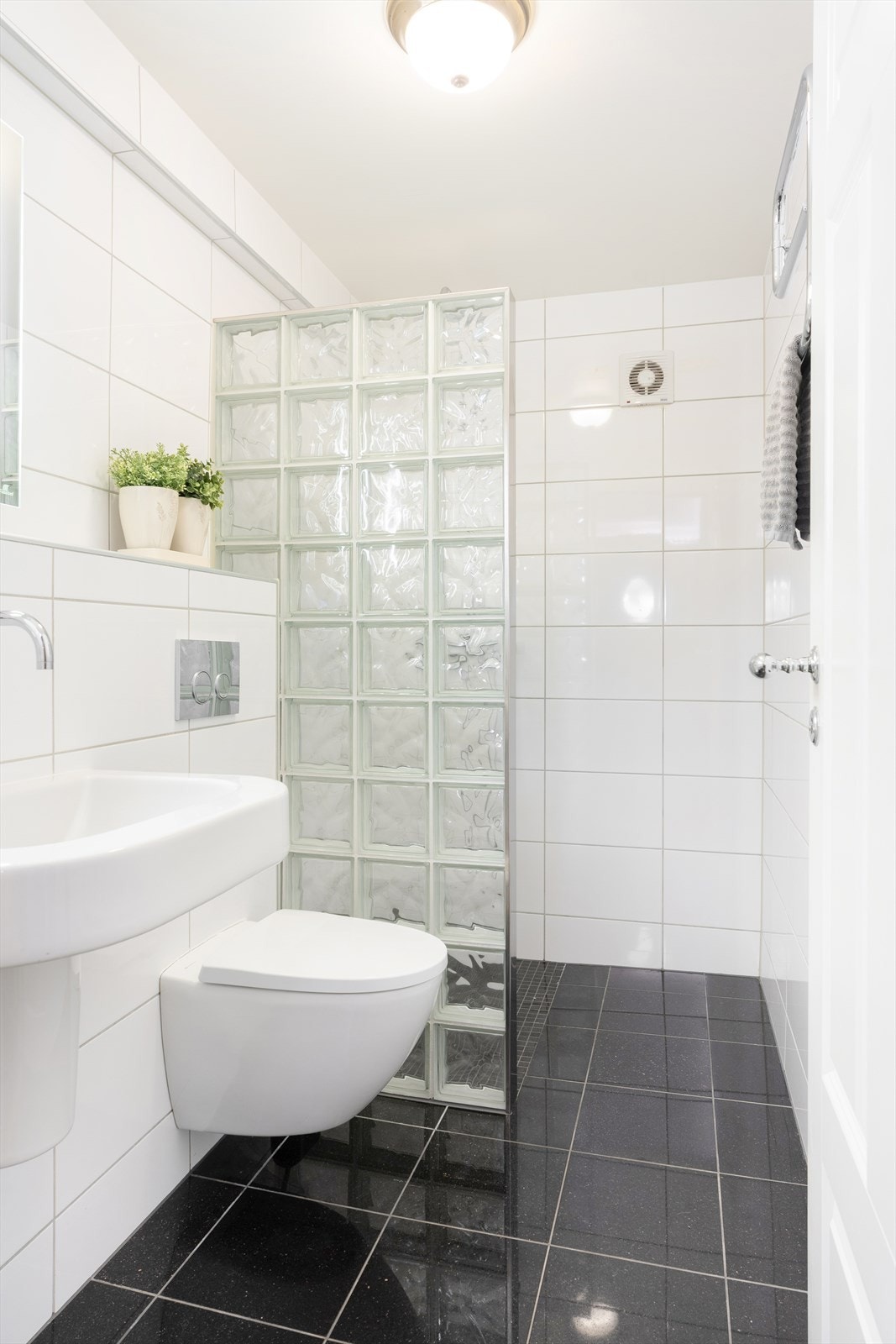 Flott helfliset bad fra 2012 som er innredet med romslig dusjhjørne, vegghengt toalett og servant Galleribilde