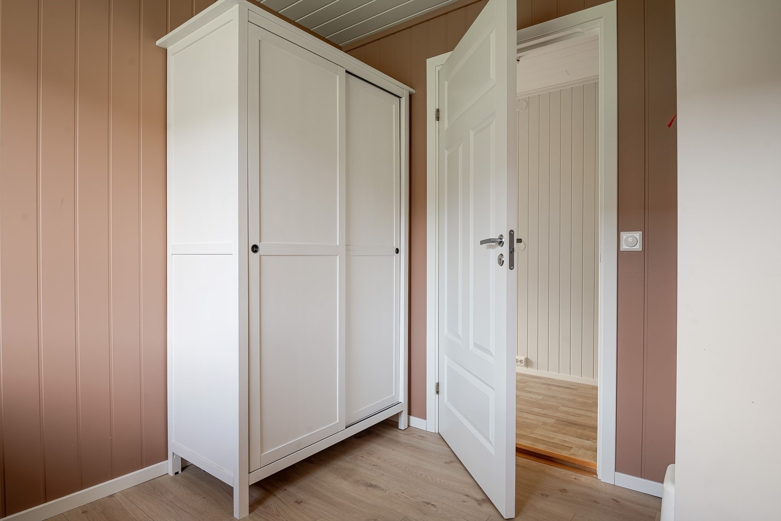 Pent oppusset i 2023 med enstavs laminat på gulv og panelplater på veggene som er malt i en innbydende varm farge. Galleribilde