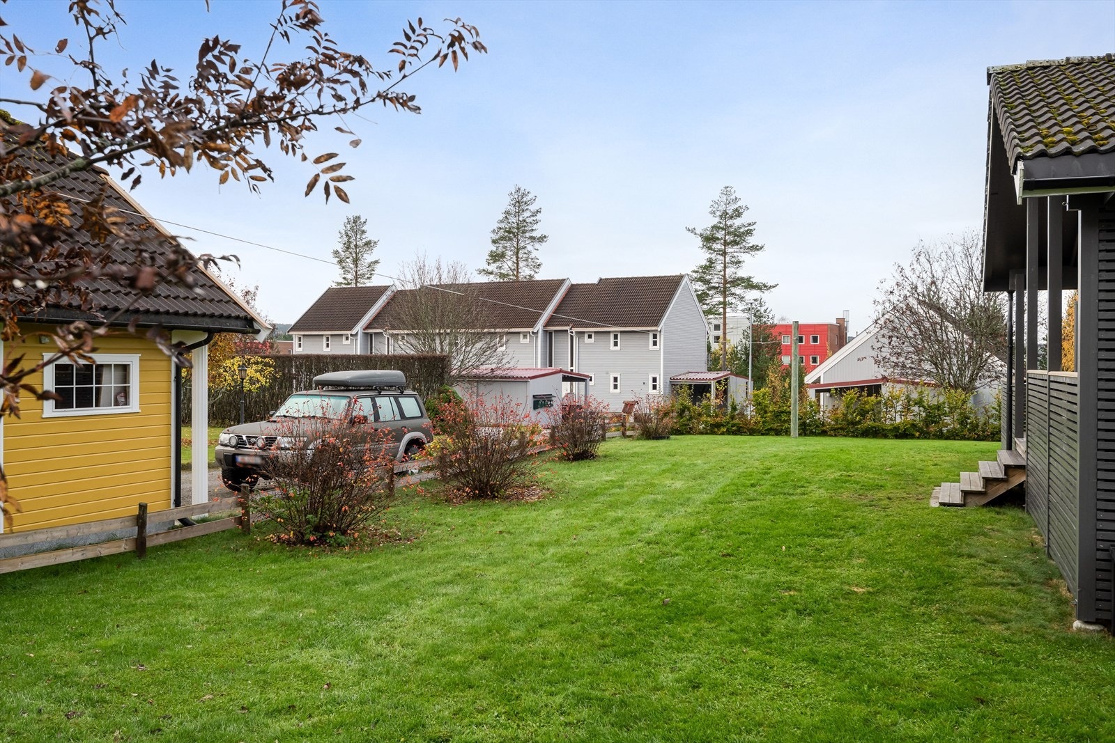 Fin, flat hage opparbeidet med plen og diverse beplantning. Hagen er delvis innhegnet med gjerde og hekk. Galleribilde